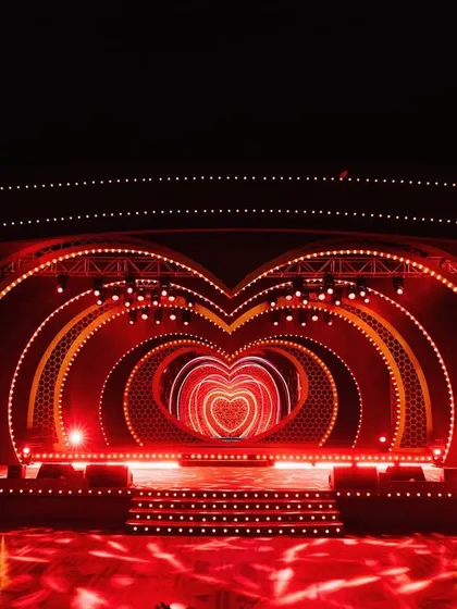The grand, heart-shaped stage I designed for the Sangeet, with concentric layers of glowing red hearts, creating a spectacular backdrop.