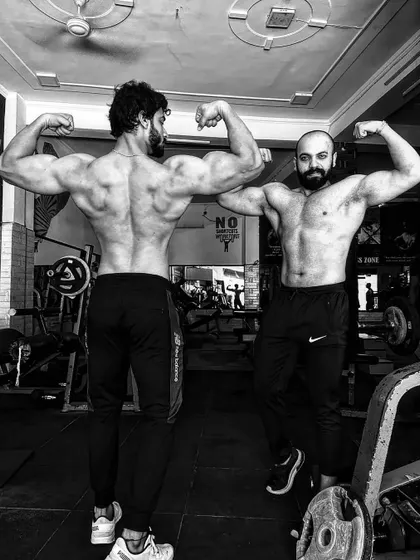 The stage is calling. Posing with a gym partner, both showing our back development.