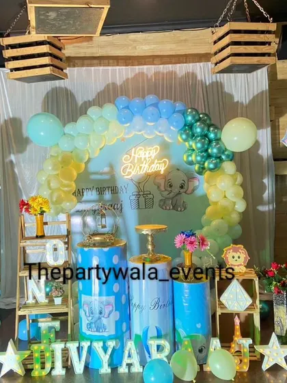 A charming baby elephant theme in a rustic setting, with wooden crates and a pastel balloon arch.