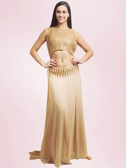 A model showcasing a stylish gold two-piece set. This outfit includes a textured crop top and a flowing skirt, designed for a modern and glamorous party look.