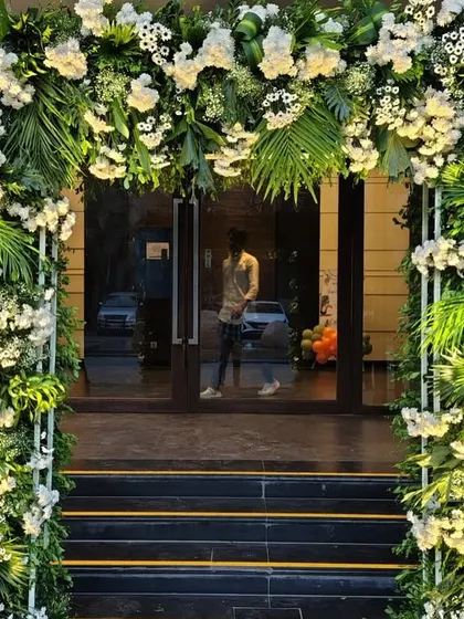 A lush and elegant floral archway, demonstrating that our decor skills extend beyond balloons. This beautiful entrance, made of white flowers and rich greenery, is perfect for a sophisticated wedding or upscale event.