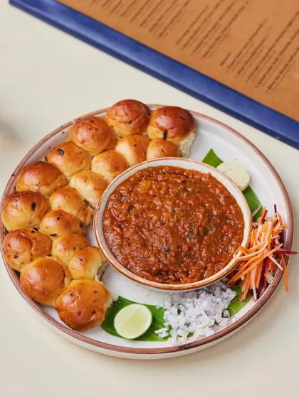 A full platter of our signature Pav Bhaji, with its vibrant bhaji, a circle of soft buns, and all the fixings. It's a feast for the eyes and the palate.