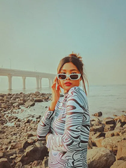 A stylish solo portrait at Bandra Bandstand. The model's pose and the iconic Sea Link in the background make for a modern and fashionable shot.