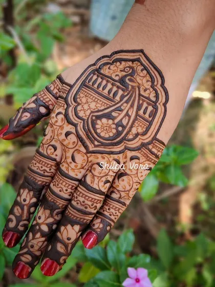 A close-up of the guest's peacock mehndi, showing the intricate details.