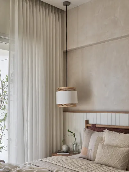The oak-finished bed with a warm rust-brown boucle fabric stands gracefully against a wainscoted wall. The wall itself is a canvas of tranquility, painted in a captivating blend of ivory and beige textures.