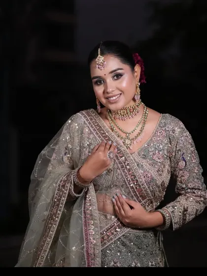A happy client posing in a grey and pink embroidered lehenga. This is one of our most popular plus-size friendly options.
