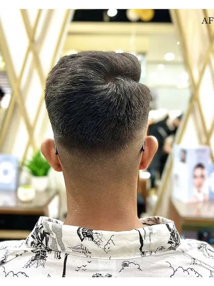 A perfect haircut is all in the details. This image displays the back view of a flawless skin fade, showcasing the clean lines and seamless blending our barbers achieve for a sharp, professional finish.
