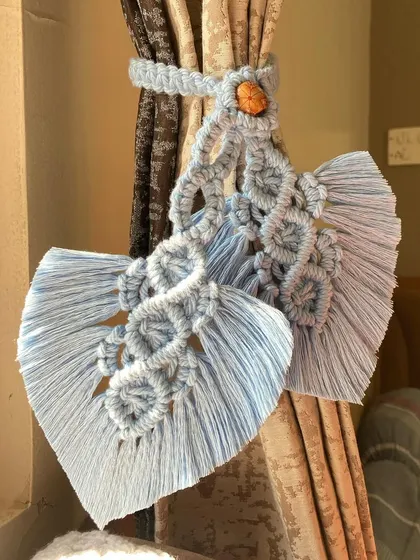 Our macrame curtain holders are a beautiful way to style your drapes. This design features intricate knots and a leaf shape, adding a touch of boho charm to your windows.