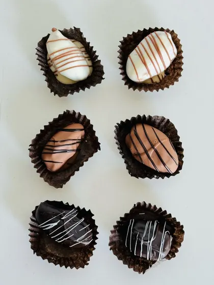 A minimalist shot of my assorted stuffed dates, coated in white, milk, and dark chocolate.