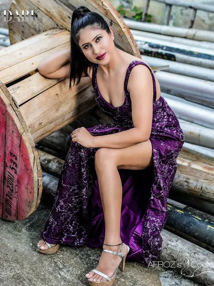 A full-length shot of a model in a custom purple sequin gown. The dress is designed with a thigh-high slit and a deep neckline for a glamorous, red carpet-ready look.