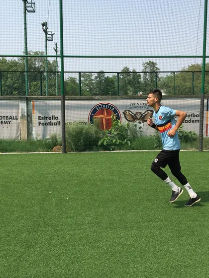 A player warming up with a light jog across the turf. Proper warmups are a crucial part of every session to prepare the body for high-intensity training and prevent injuries.
