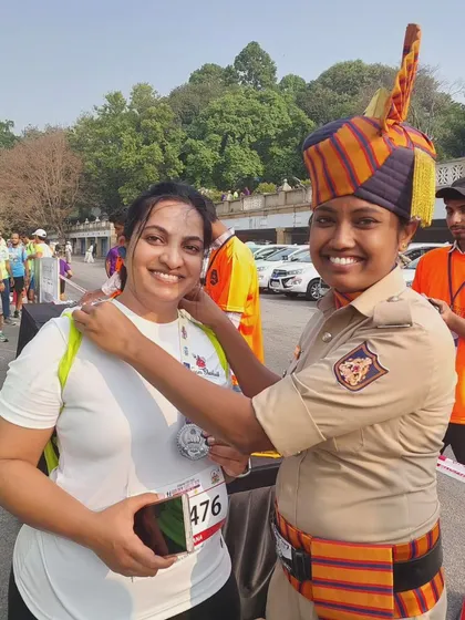 A team member receiving her medal from a Karnataka State Police officer, a proud moment of achievement.
