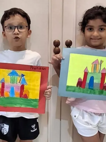 Two proud students holding up their completed castle drawings. It's wonderful to see their different interpretations of the same lesson, from the colors of the towers to the background.