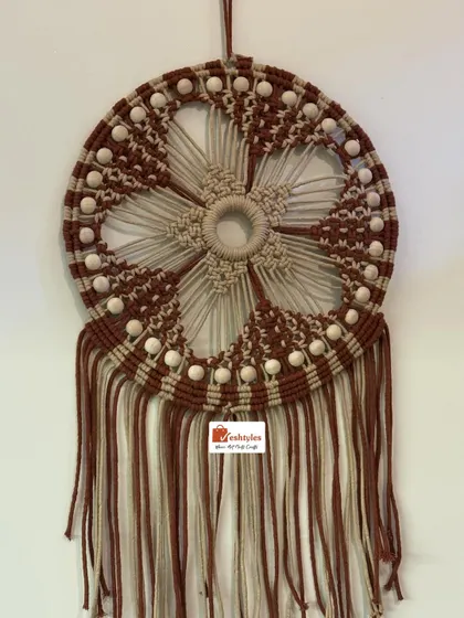 This is my large mandala dream catcher, a piece that requires a lot of focus and intricate knotting. The flower-like pattern is created with brown and beige cotton cords and detailed with wooden beads, making it a captivating centerpiece.