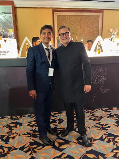 It's an honor to serve distinguished guests at weddings. Here I am with a guest in front of our elegant bar setup.