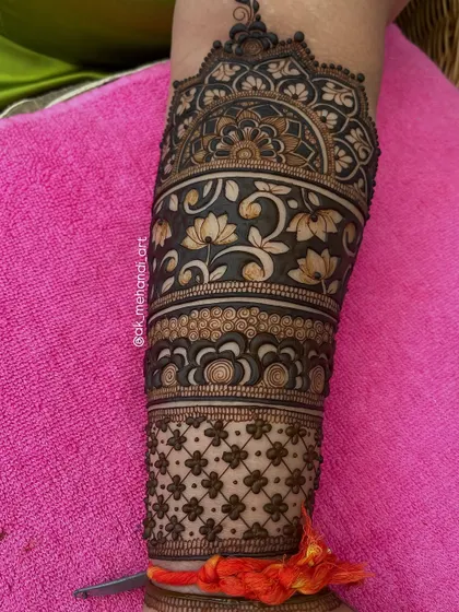 A full bridal arm design with multiple bands of different patterns, including floral vines and geometric grids.