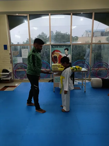 A student receives his yellow belt.