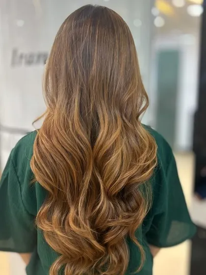 A gorgeous Caramel Balayage with beautiful, flowing waves. This look is a testament to our Salon Director's expertise in creating warm, wearable colour.