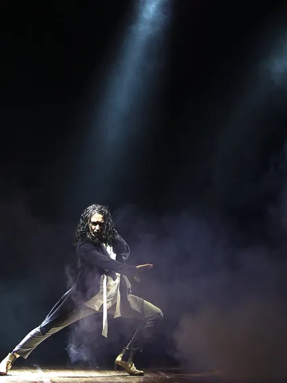 A dramatic solo performance, with smoke and spotlights creating a theatrical atmosphere.