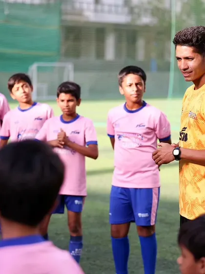 A coach instructs a group of young players at our Pune Summer Camp.