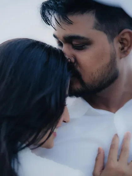 A soft and tender pre-wedding portrait of a groom-to-be kissing his partner's forehead, a classic gesture of love and protection.
