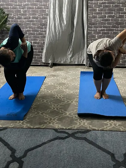 In this personal training session, I am guiding a student through a standing side bend and twist, focusing on balance and spinal mobility.