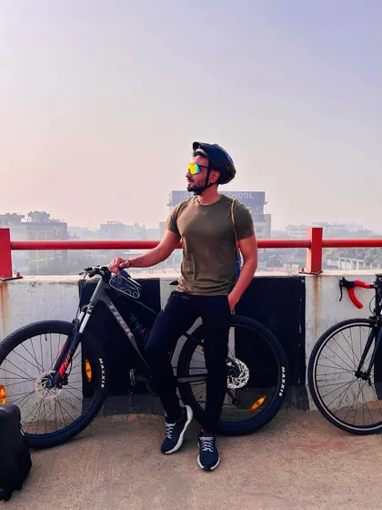 Posing with the bike on a flyover, this image captures the urban landscape of our endurance rides and the personal sense of achievement.