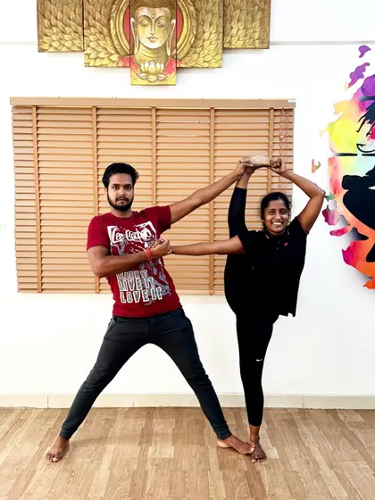Another example of partner-assisted stretching, focusing on achieving a full standing split with stability and control.