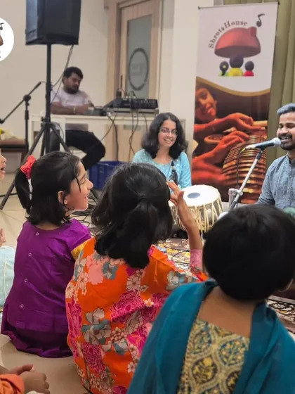 An interactive session where a musician sings with the children, teaching them about melody and rhythm. The joy and participation in this photo say it all.