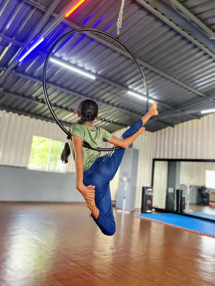 Every child is an artist. Here, a student creates a beautiful shape with her body on the aerial hoop, demonstrating her flexibility and control.