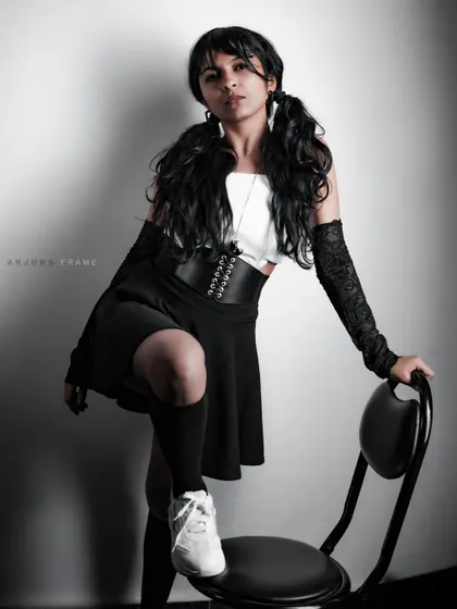 Using a chair as a prop to create a strong, assertive pose. This shot from the 'Pretty in Punk' series showcases a complete look, from the pigtails down to the platform sneakers.