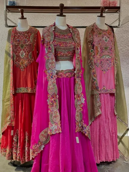 A full view of three exquisite outfits from Petticoat Lane, showcasing a vibrant mix of colors, heavy embroidery, and unique silhouettes.