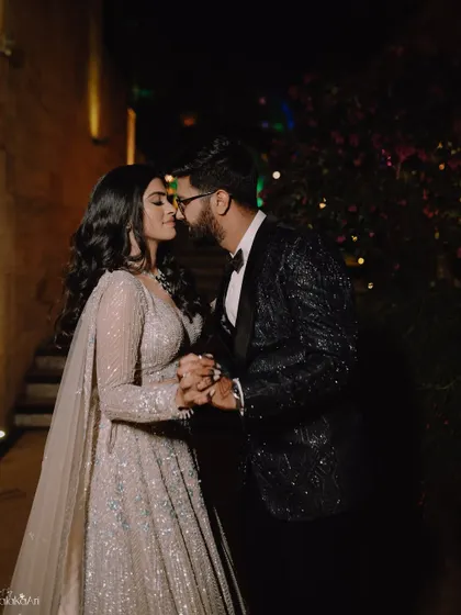 A romantic pre-kiss moment between the couple during their evening celebration. The low lighting and their closeness create a very intimate and moody portrait.
