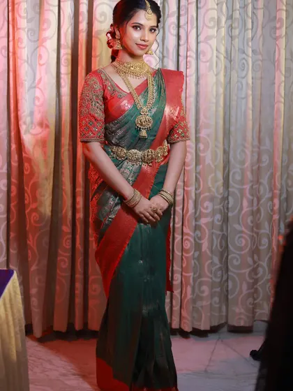 A full-length view of this gorgeous bride in her green and red Kanjivaram saree. The drape is tailored to be comfortable yet elegant for all the wedding rituals.