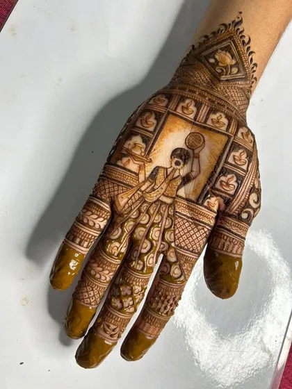 A full-palm Karwa Chauth scene, capturing the moment a woman looks at the moon through a sieve. The design is framed by small, decorative diyas, enhancing the festive feel.