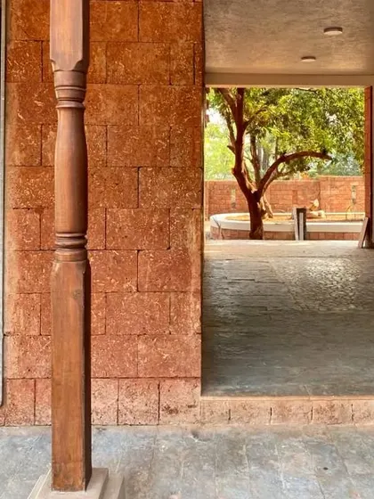 Another view of Maison Rouge during construction, highlighting the reclaimed timber columns and the open veranda that connects the different parts of the house.