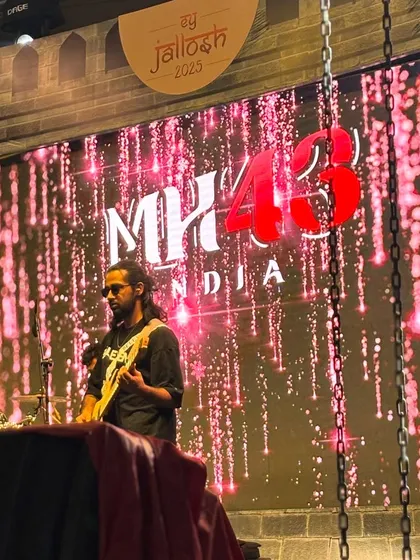 Our guitarist against the massive MH43 India backdrop at the EY Jallosh 2025 event. The stage production was top-notch.