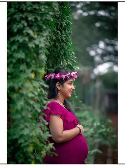 A lovely side-profile shot, framed by lush greenery, capturing a happy and candid moment.
