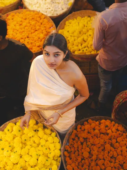 An overhead shot in the flower market, surrounded by baskets of marigolds. This perspective offers a unique and colorful view of the scene.