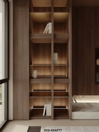 We design smart storage solutions that are part of the decor. This floor-to-ceiling built-in bookshelf features integrated backlighting to create a warm glow and highlight decorative objects.