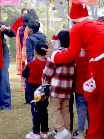 A mother captures a precious moment on her phone as her children meet Santa Claus.