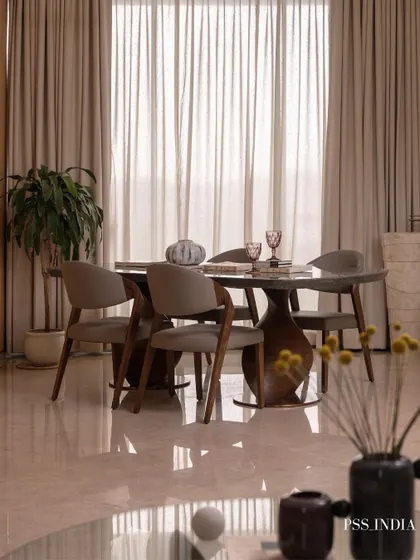 Every detail on the table tells a story. This modern dining set, with its sculptural base and sleek chairs, is styled with colorful glassware and a simple vase, making every meal feel memorable.