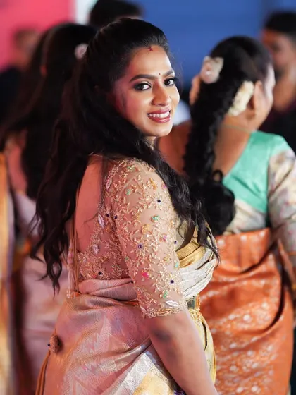 This client looks gorgeous in her gold and pastel saree. The custom-designed blouse with intricate embroidery adds a touch of glamour to her look for the reception.
