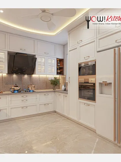 A look at a timeless all-white U-shaped kitchen. This design maximizes space with floor-to-ceiling cabinetry, integrated double ovens, and a dedicated space for a side-by-side refrigerator, creating a bright and highly functional cooking environment.