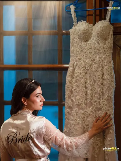 The bride in her getting-ready robe, looking at her beautiful white wedding gown. This shot tells the story of the beginning of her wedding day.