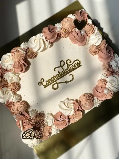A closer look at the delicate piping on this engagement sheet cake. The combination of different piping techniques and soft colors creates a beautiful, textured frame.
