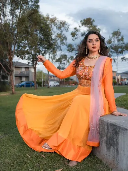 A full-length shot showing the beautiful flow and flare of this orange Anarkali.