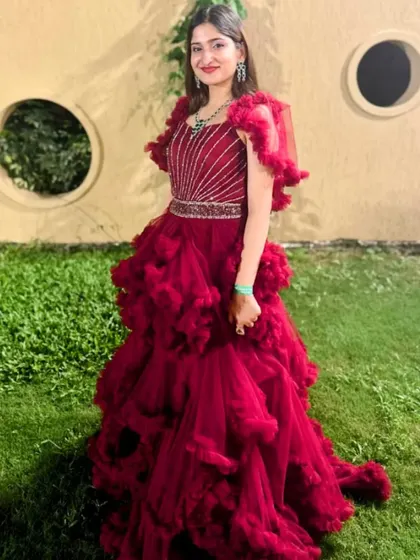 A full-length shot of the maroon ruffle ballgown. The unique color and dramatic silhouette make it a standout choice for any special occasion.