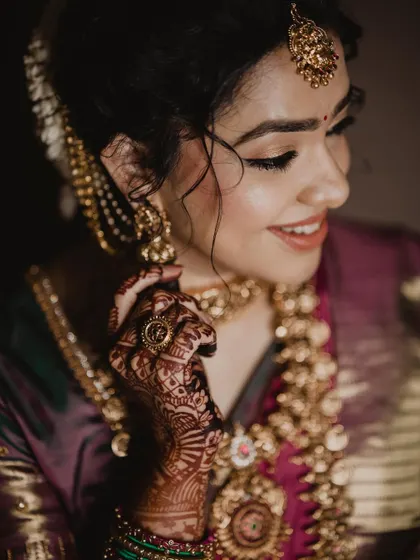 A close-up showing the intricate details of her temple jewelry and the soft, winged eyeliner that defines her eyes.