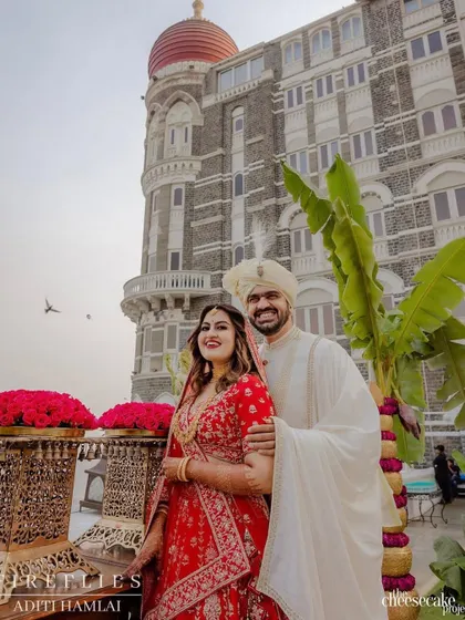 A beautiful portrait of Vijayshree and Omkar at their wedding, with the iconic Taj Mahal Palace hotel as the backdrop. The traditional decor elements like the banana tree perfectly frame this timeless shot.